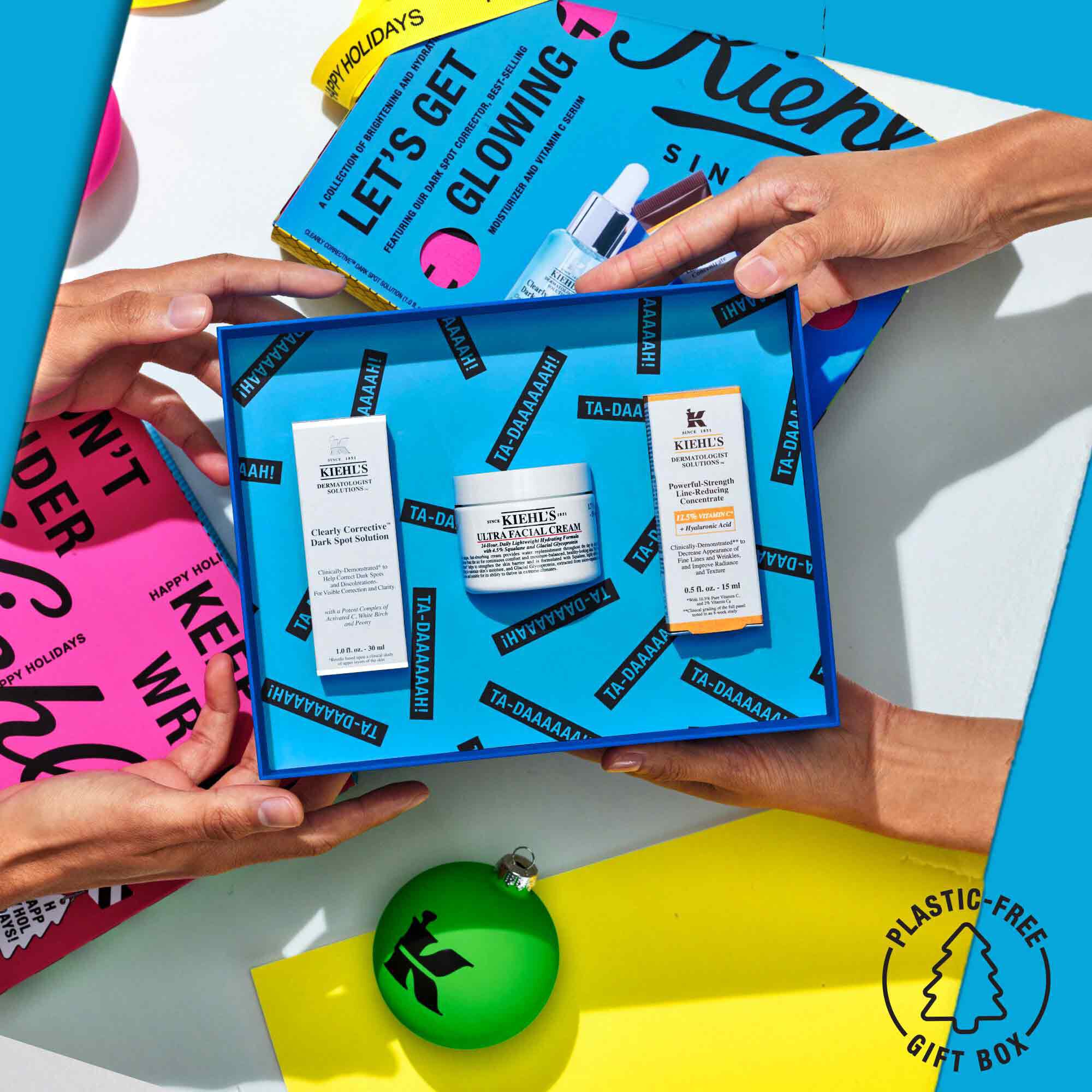 An open Kiehl's Let's Get Glowing Gift Set being gifted with a festive background 
