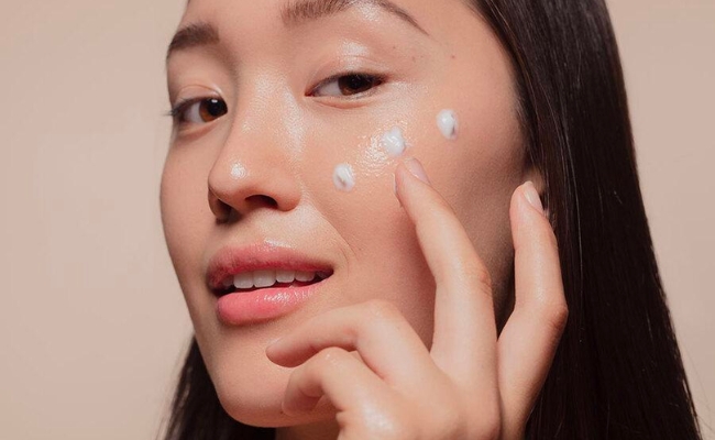 Chấm kem chống nắng lên từng điểm trên khuôn mặt